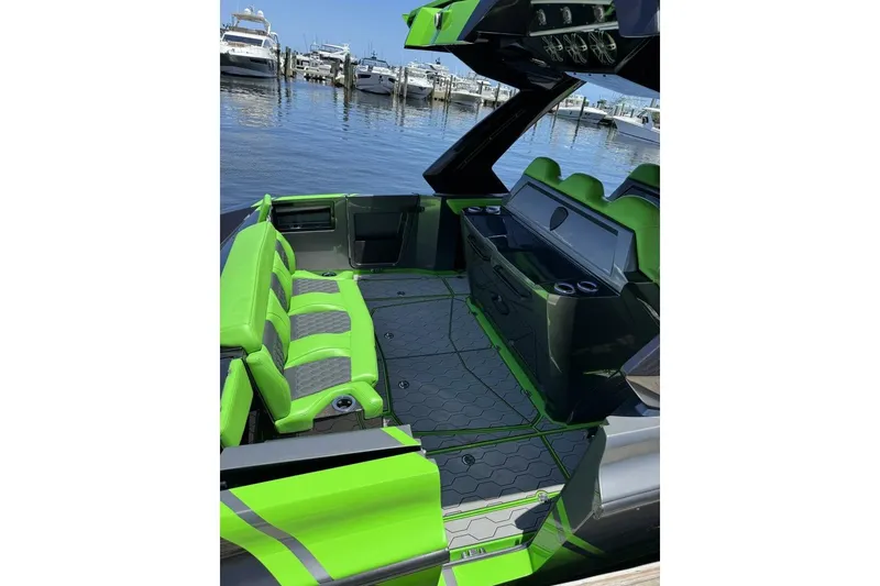 Slide: The Image of 2023 Adrenaline 47 boat interior with vibrant green seating, docked at a marina. - 6