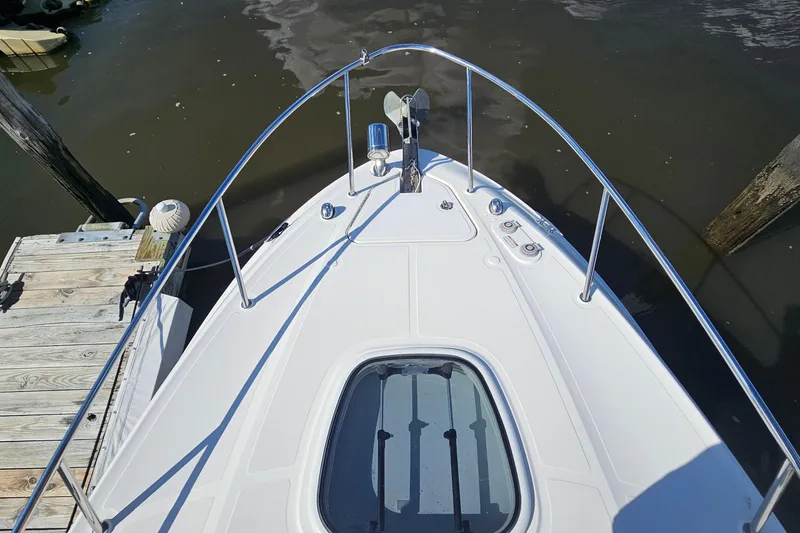 Slide: The Image of Bow view of 2015 Sea Ray 260 Sundancer docked at a wooden pier. - 14