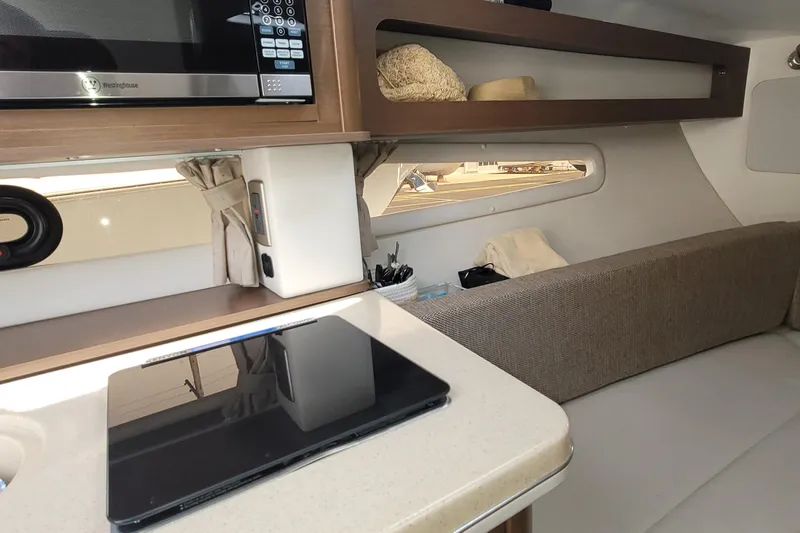 Slide: The Image of Interior of 2015 Sea Ray 260 Sundancer with microwave and seating area. - 18