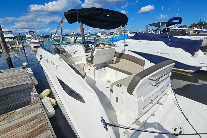 Slide: The Image of 2015 Sea Ray 260 Sundancer docked at marina under clear blue sky. - 2