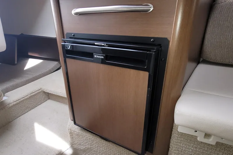 Slide: The Image of Interior of 2015 Sea Ray 260 Sundancer featuring a compact Dometic refrigerator. - 25