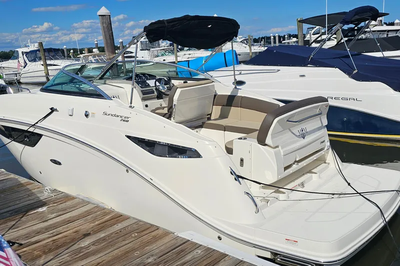 Slide: The Image of 2015 Sea Ray 260 Sundancer docked at marina, featuring sleek design and spacious seating. - 3