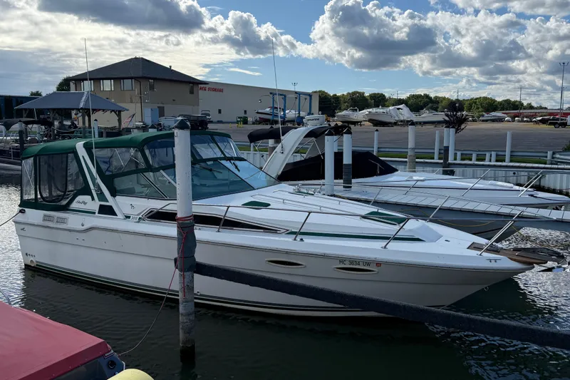 Slide: The Image of 1989 Sea Ray 300 Weekender docked at marina under cloudy sky. - 1