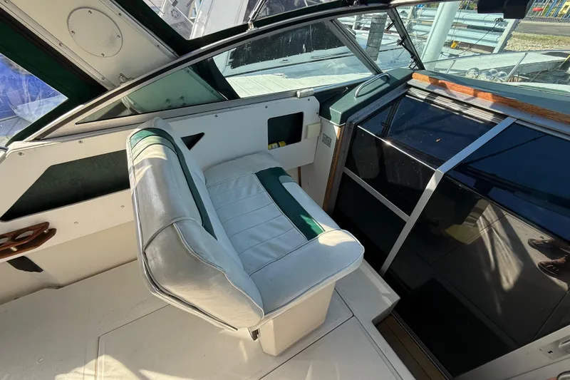 Slide: The Image of 1989 Sea Ray 300 Weekender cockpit with white and green seating, sleek dashboard design. - 10