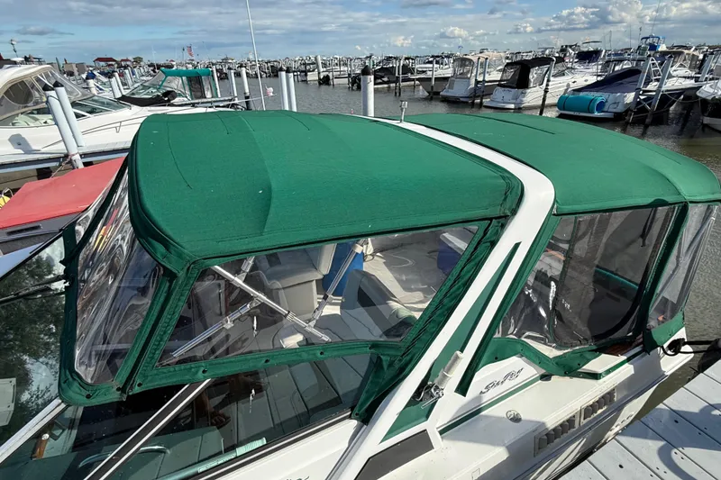 Slide: The Image of 1989 Sea Ray 300 Weekender with green canopy docked at a marina. - 16
