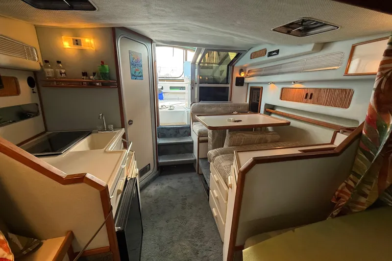 Slide: The Image of Interior of 1989 Sea Ray 300 Weekender boat with kitchenette and dining area. - 19