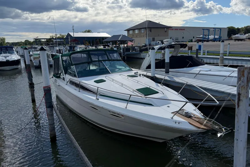 Slide: The Image of 1989 Sea Ray 300 Weekender docked at marina under cloudy sky. - 2