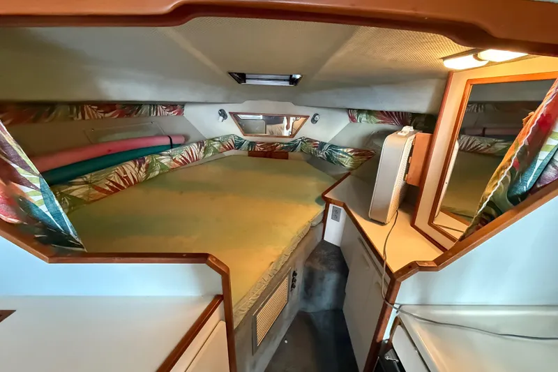 Slide: The Image of Interior cabin of 1989 Sea Ray 300 Weekender with colorful curtains and cozy sleeping area. - 20