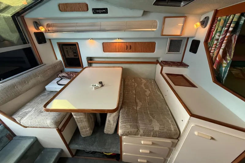 Slide: The Image of 1989 Sea Ray 300 Weekender cabin interior with dining area and cozy seating. - 22