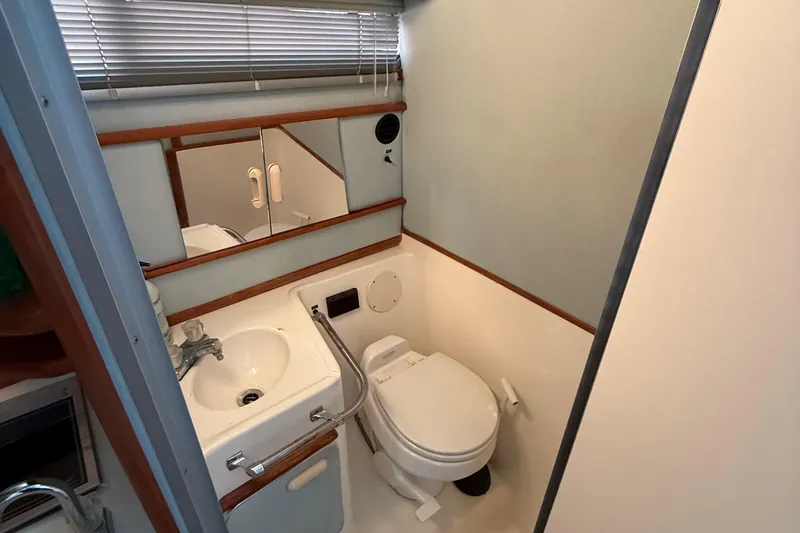 Slide: The Image of 1989 Sea Ray 300 Weekender boat bathroom with sink, toilet, and mirror. - 24