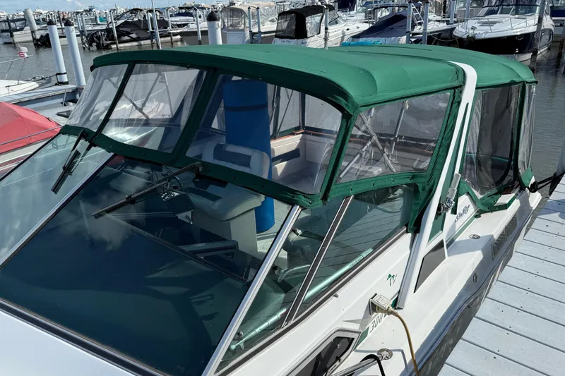 Slide: The Image of 1989 Sea Ray 300 Weekender boat with green canopy docked at marina. - 5