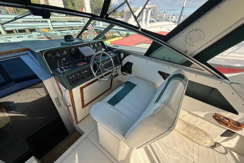 Slide: The Image of 1989 Sea Ray 300 Weekender helm with steering wheel and control panel at marina. - 9