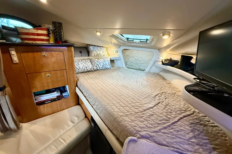 Slide: The Image of Cozy cabin interior of 2002 Regal Commodore 2860 with bed, storage, and TV. - 12