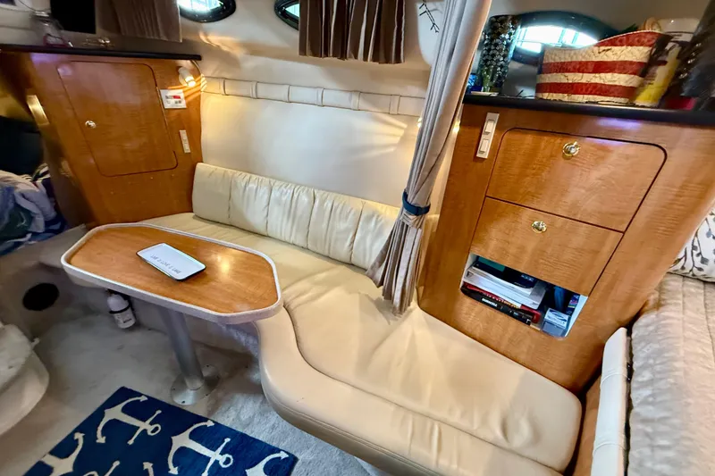 Slide: The Image of Interior of 2002 Regal Commodore 2860 boat with cozy seating and wooden cabinetry. - 13