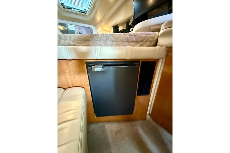 Slide: The Image of Interior of 2002 Regal Commodore 2860 with compact fridge and cozy seating area. - 18