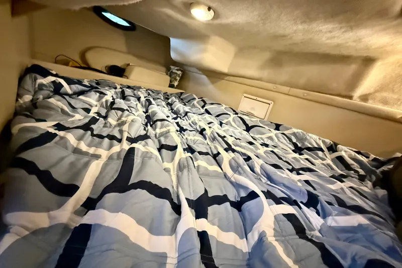 Slide: The Image of Cozy cabin interior of 2002 Regal Commodore 2860 with patterned bedding. - 19
