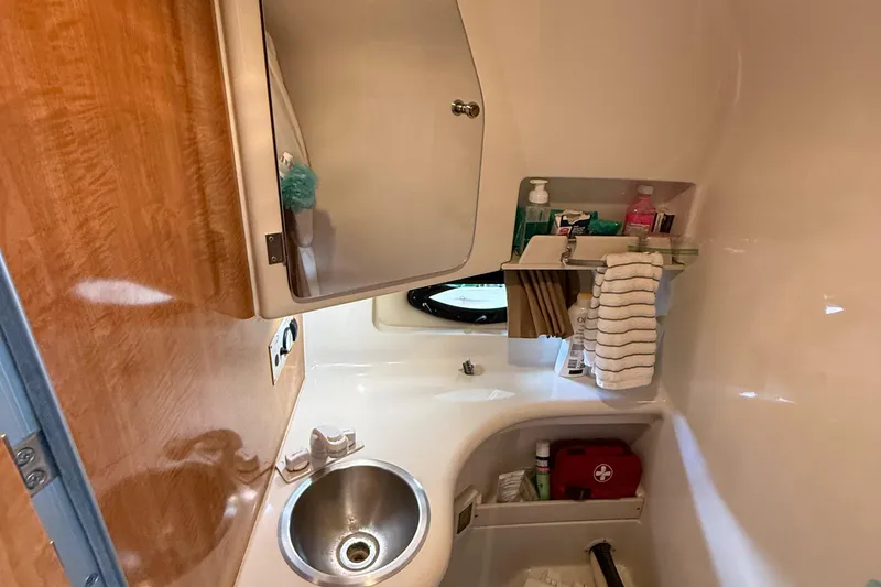 Slide: The Image of Compact bathroom in 2002 Regal Commodore 2860 boat with sink, mirror, and storage shelves. - 22