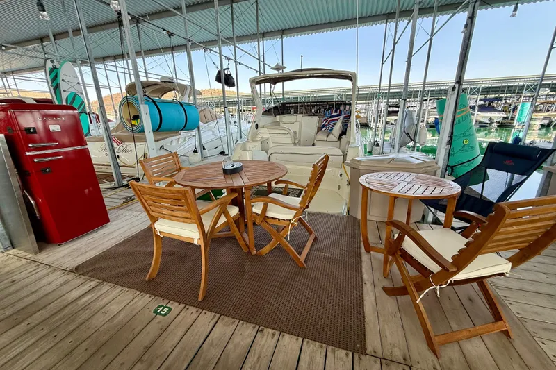 Slide: The Image of Docked 2002 Regal Commodore 2860 with outdoor seating and red fridge under covered marina. - 30