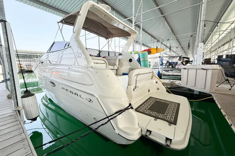 Slide: The Image of 2002 Regal Commodore 2860 boat docked in a covered marina, rear view. - 31