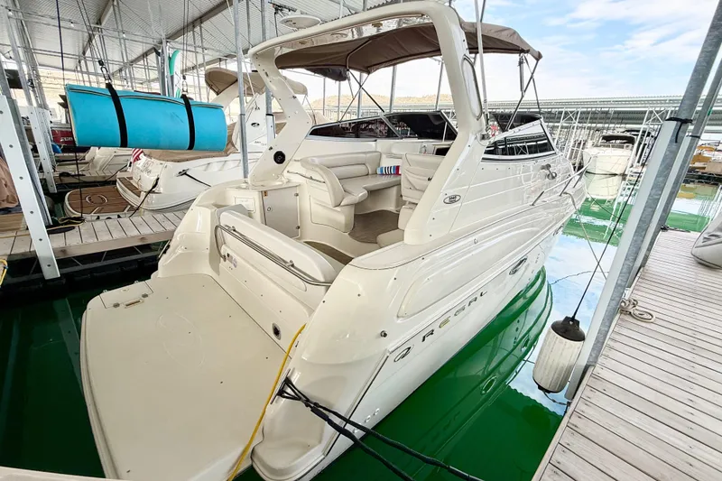 Slide: The Image of 2002 Regal Commodore 2860 boat docked in marina, featuring spacious deck and seating area. - 35