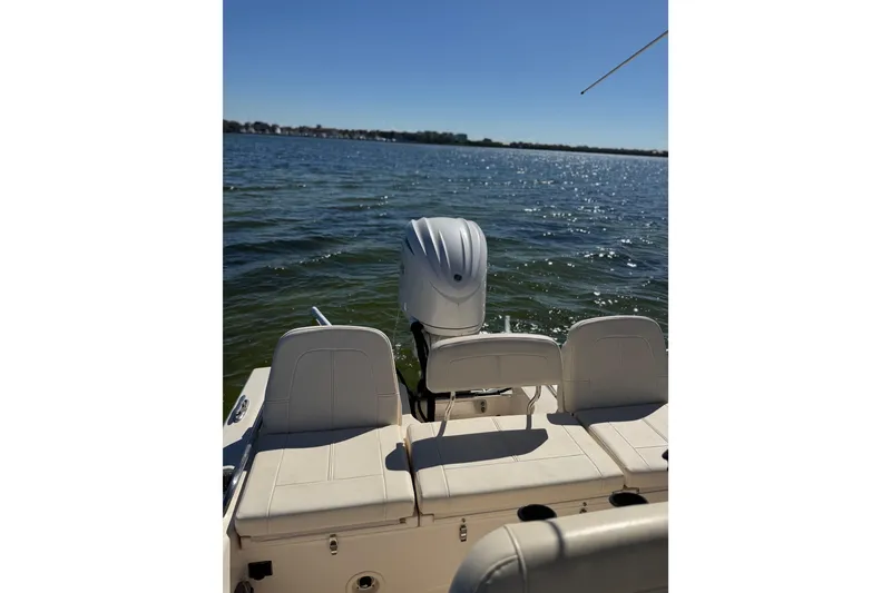 Slide: The Image of 2023 Grady-White 251 Coastal Explorer boat on water, featuring rear seating and outboard motor. - 11