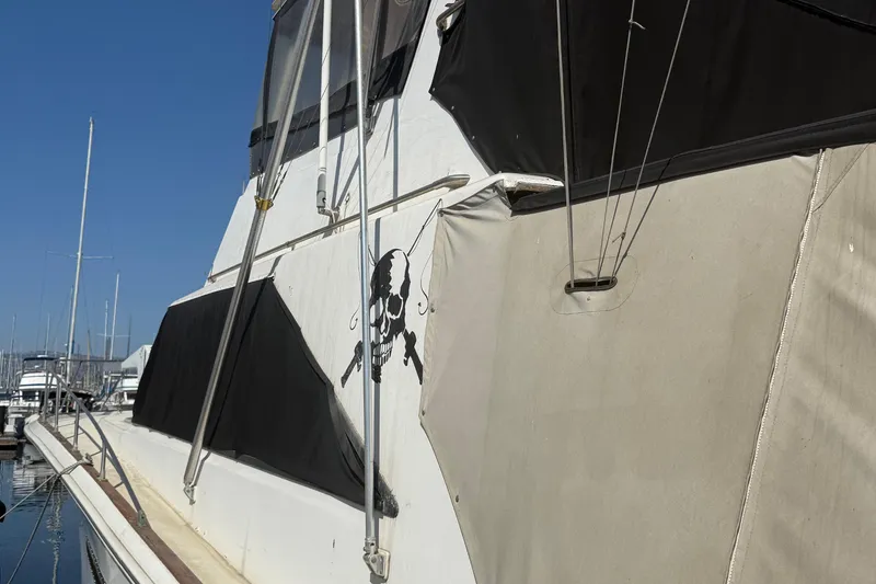 Slide: The Image of 1974 Pacemaker 48 Sportfisherman boat with skull design, docked in marina. - 13