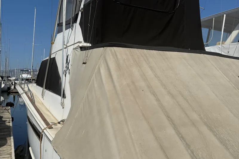 Slide: The Image of 1974 Pacemaker 48 Sportfisherman yacht docked at marina, featuring beige and black canvas covers. - 14