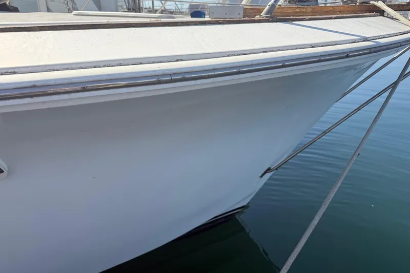 Slide: The Image of 1974 Pacemaker 48 Sportfisherman boat docked, showing sleek white hull and mooring lines. - 15