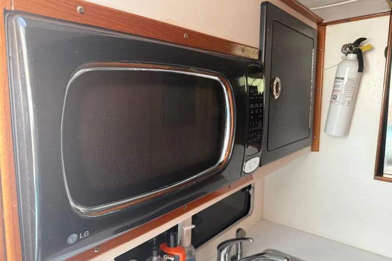 Slide: The Image of Microwave and fire extinguisher in 1974 Pacemaker 48 Sportfisherman boat kitchen. - 28