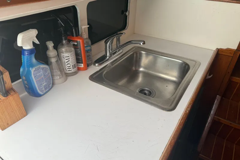 Slide: The Image of 1974 Pacemaker 48 Sportfisherman kitchen sink with cleaning supplies on countertop. - 35