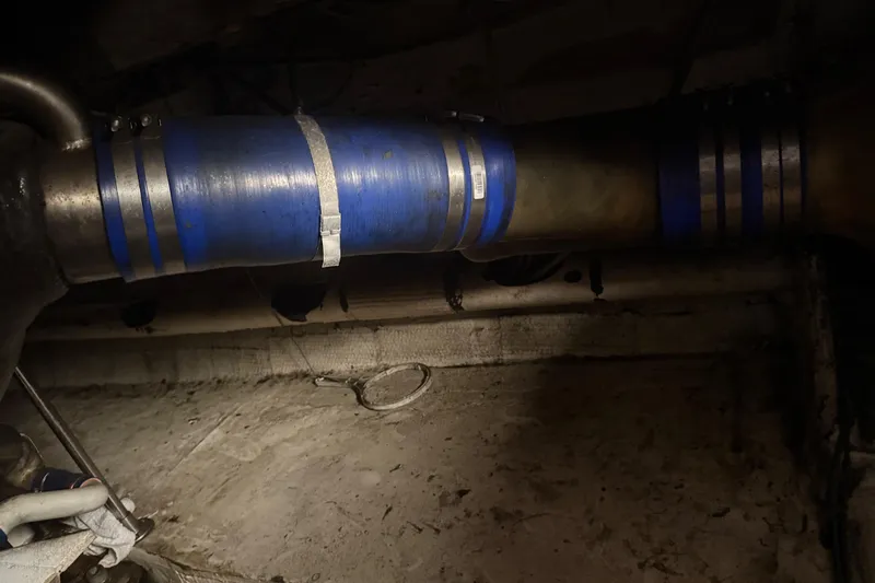 Slide: The Image of Engine room of 1974 Pacemaker 48 Sportfisherman with blue hose and metal clamps. - 48