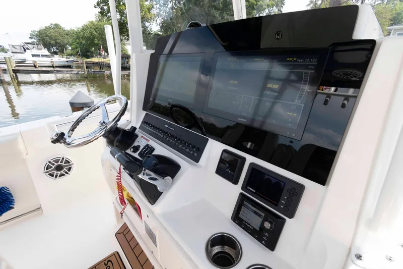 Slide: The Image of 2020 Cobia 320 Center Console boat interior with dual captain's chairs and steering wheel. - 14