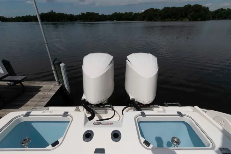 Slide: The Image of 2020 Cobia 320 Center Console boat with Garmin radar, flags, and trees in the background. - 23