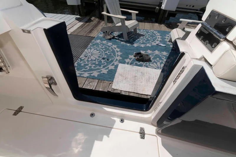 Slide: The Image of 2020 Cobia 320 Center Console boat with dual outboard engines on a calm lake. - 24