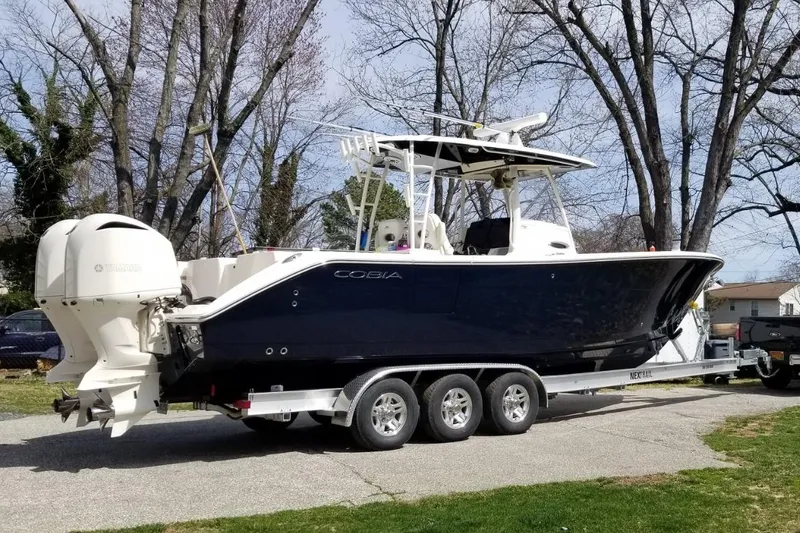 Slide: The Image of 2020 Cobia 320 Center Console docked at a waterfront restaurant with a blue exterior. - 7