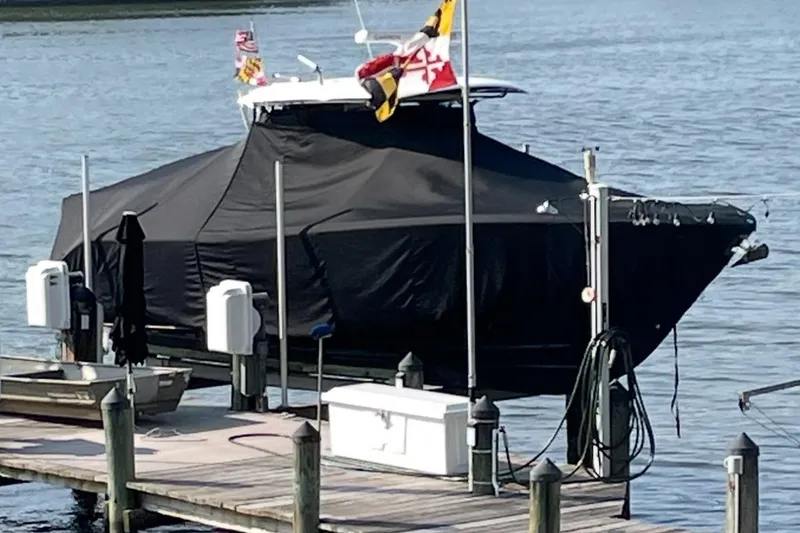 Slide: The Image of 2020 Cobia 320 Center Console boat on trailer, parked outdoors near trees. - 8