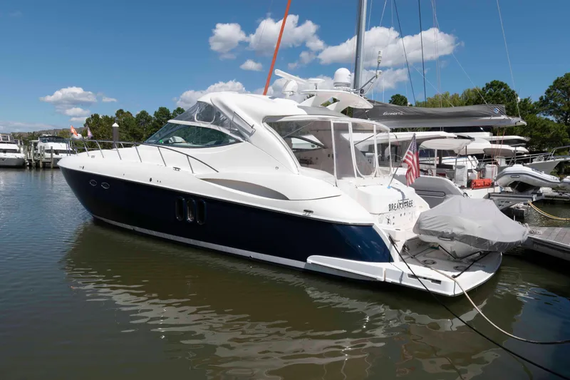 The Image of 2007 Cruisers Yachts 520 Express docked in a marina under a clear blue sky. - 0