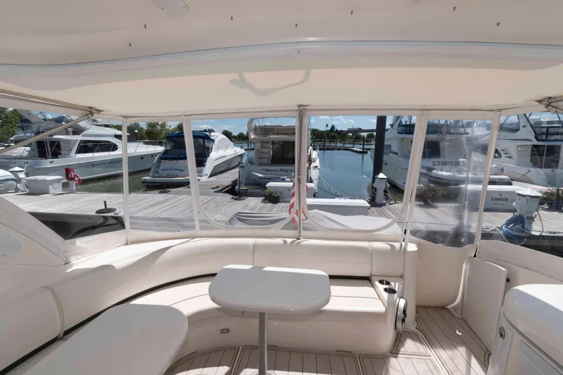 Slide: The Image of 2007 Cruisers Yachts 520 Express interior view at marina, featuring seating and table. - 3