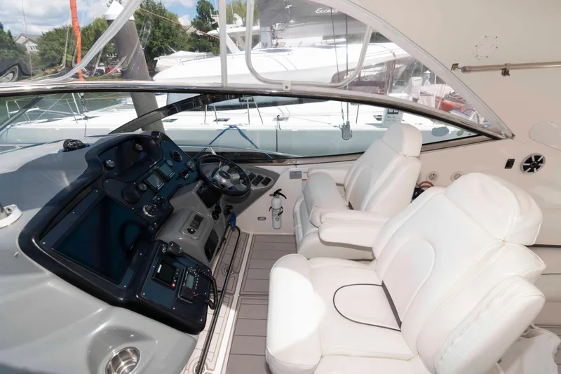 Slide: The Image of 2007 Cruisers Yachts 520 Express cockpit with white leather seats and modern dashboard. - 5
