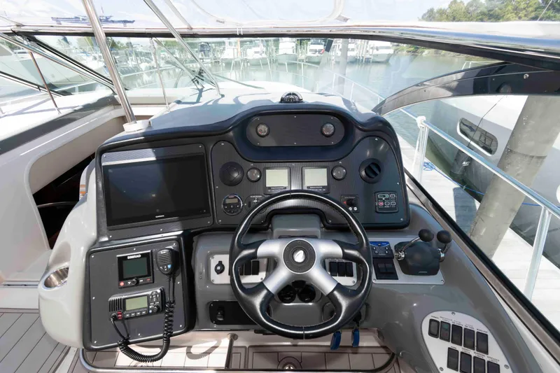 Slide: The Image of 2007 Cruisers Yachts 520 Express helm with advanced navigation controls and steering wheel. - 7