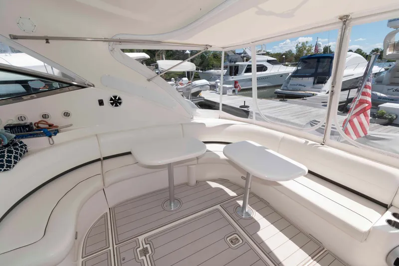 Slide: The Image of Luxurious 2007 Cruisers Yachts 520 Express interior with seating and tables, docked at marina. - 2