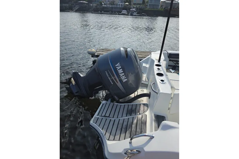 Slide: The Image of 2004 Polar 23 CC boat with Yamaha outboard motor on a calm waterfront. - 5