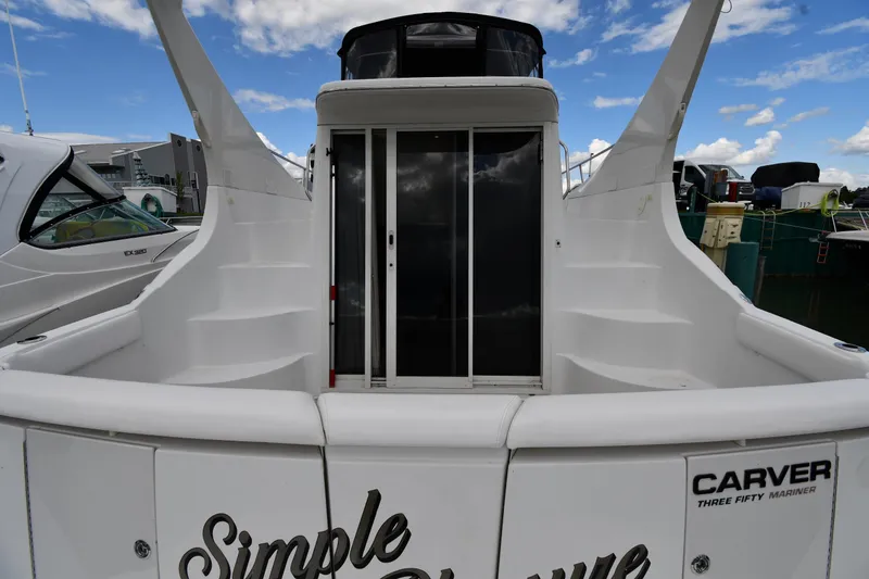 Slide: The Image of 2001 Carver 350 Mariner yacht docked, featuring spacious deck and sliding glass doors. - 13