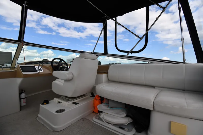 Slide: The Image of Interior of 2001 Carver 350 Mariner boat with white seating and steering wheel. - 23
