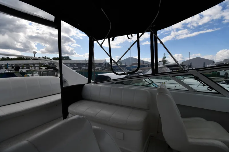 Slide: The Image of Interior view of 2001 Carver 350 Mariner yacht with white seating and marina backdrop. - 25