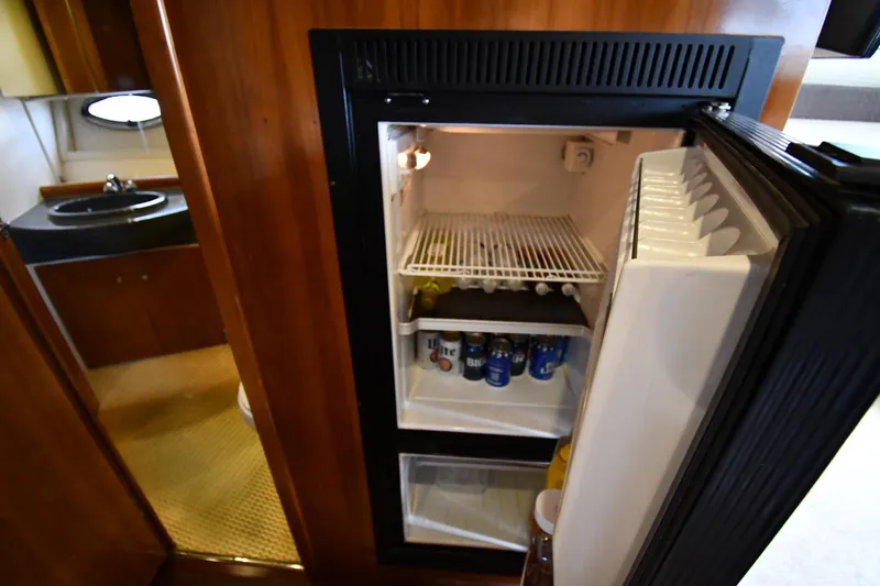 Slide: The Image of 2001 Carver 350 Mariner interior with open fridge, stocked with beverages. - 47