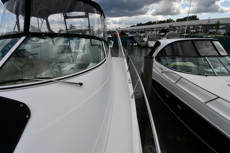 Slide: The Image of 2001 Carver 350 Mariner yacht docked beside another boat under cloudy skies. - 8