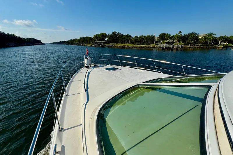 Slide: The Image of 2003 Sea Ray 400 Sedan Bridge cruising on a scenic river under a clear blue sky. - 17