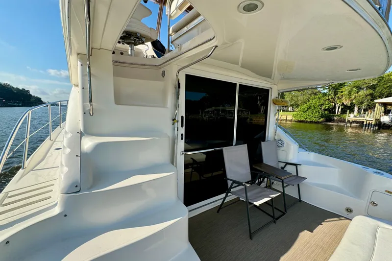 Slide: The Image of 2003 Sea Ray 400 Sedan Bridge yacht with outdoor seating, docked by a scenic waterfront. - 20