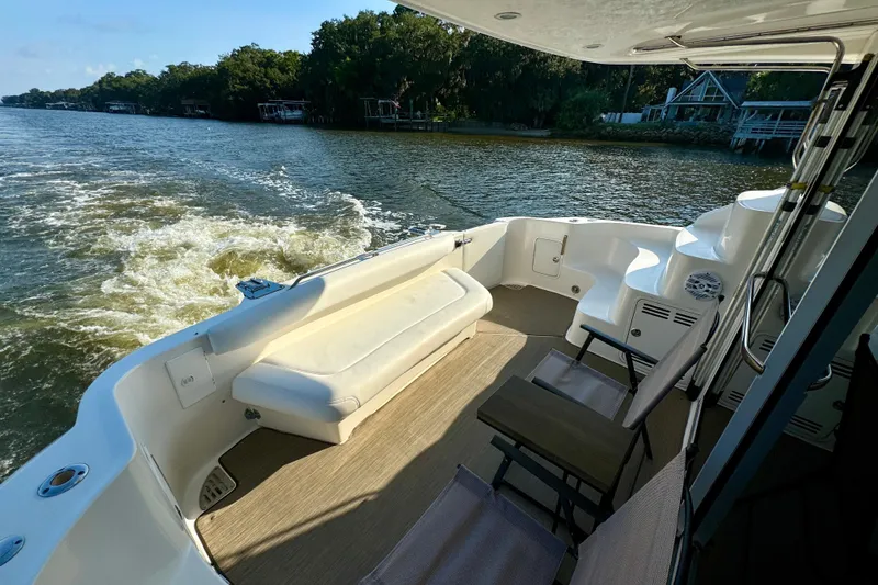 Slide: The Image of 2003 Sea Ray 400 Sedan Bridge yacht deck with seating, cruising on a scenic river. - 21